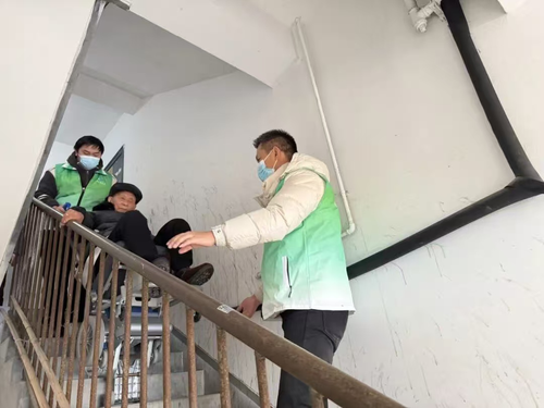 图10 志愿者借助适老化爬楼设备帮扶老年居民.png